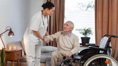 A care worker is helping an adult patient in a care home.