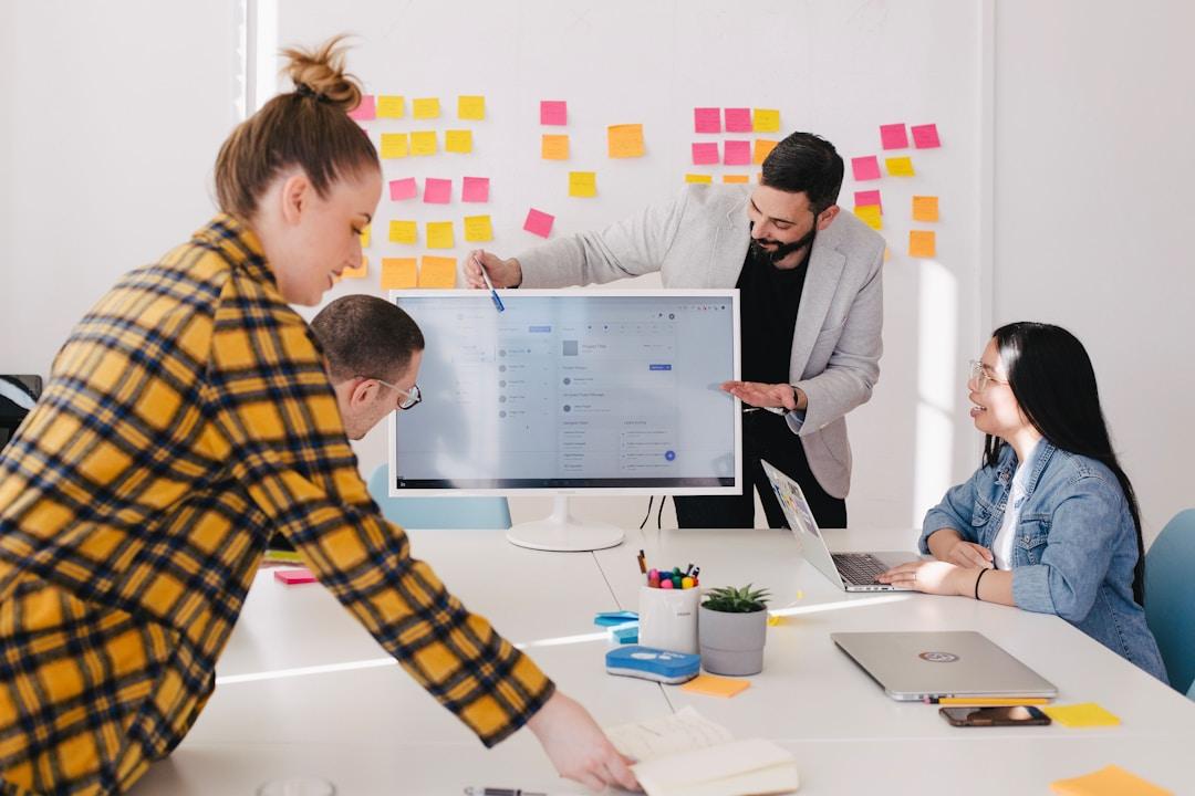 A group of professionals collaborating in an office, discussing an enterprise fax solution.