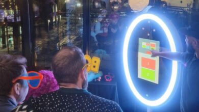 magic mirror booth at a Manchester corporate christmas party with people taking a picture wearing props