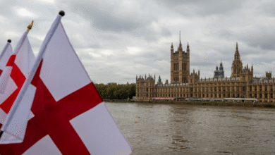 The Houses of Parliament by the Thames river on a grey cloudy day symbolizing the controversy over local councils removing St George’s Flags.