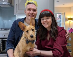 Couple with dog in home setting.